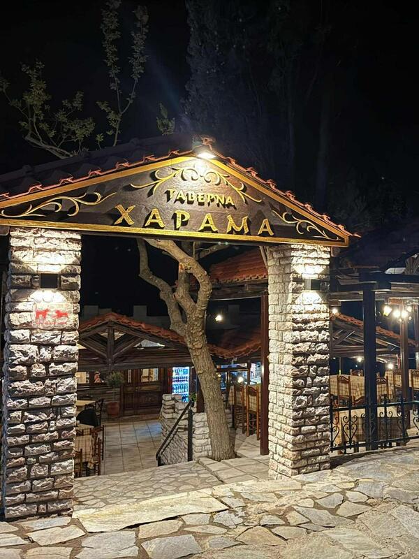 Taverna Xarama entrance at night with illuminated stone pillars