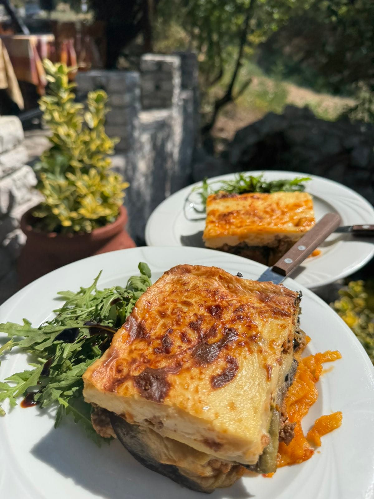 Homemade moussaka with fresh arugula served at Taverna Xarama Kastraki